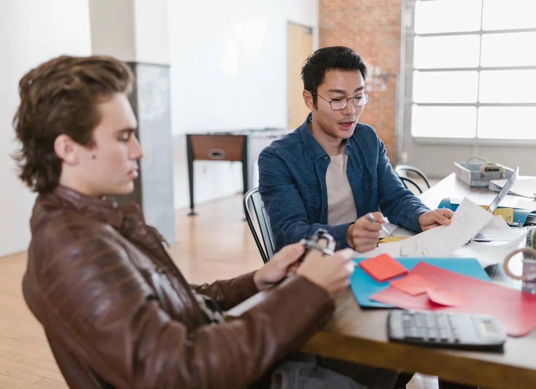 Two founders reviewing early product notes at a shared desk