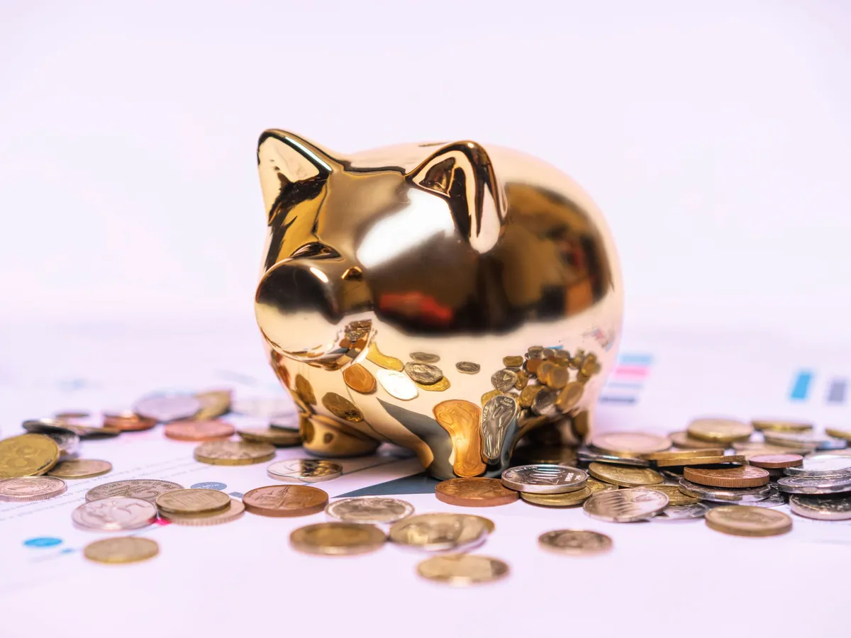A golden piggy bank resting on financial statements