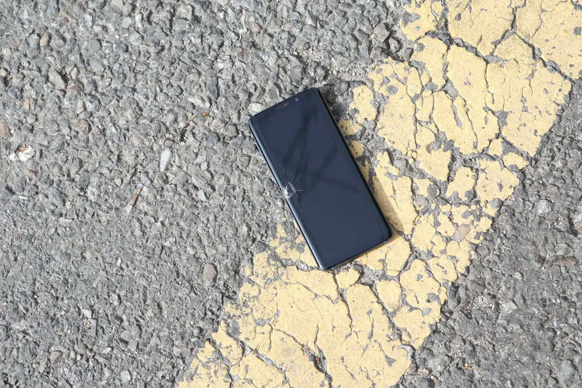 A driver photographing vehicle damage to report a claim