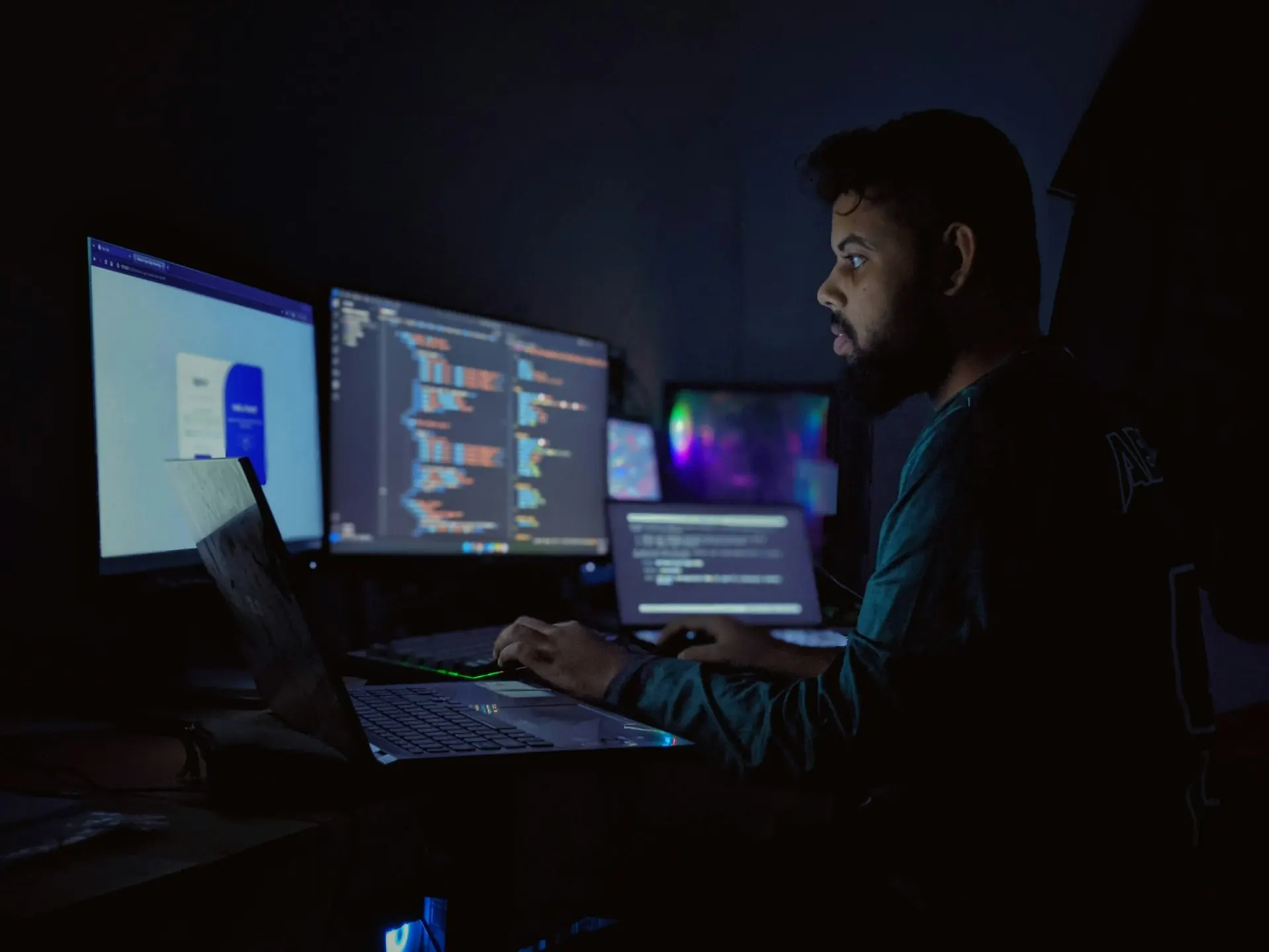 Data scientist reviewing model output across three monitors in a dark office