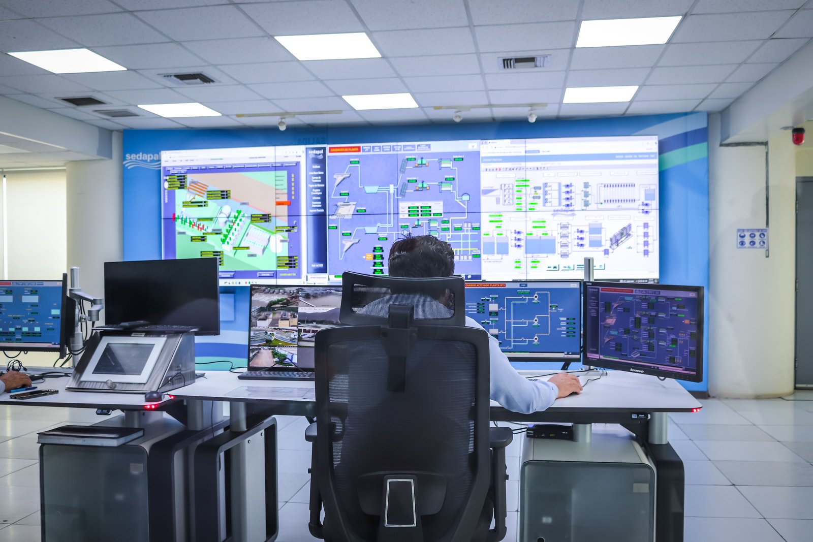 Operations team watching an autonomous agent coordinate work across a control-room wall