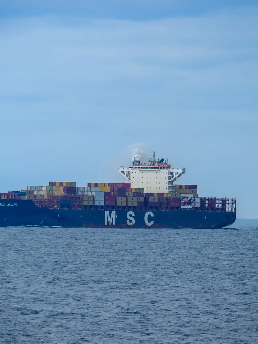 A container ship at sea carrying stacked containers