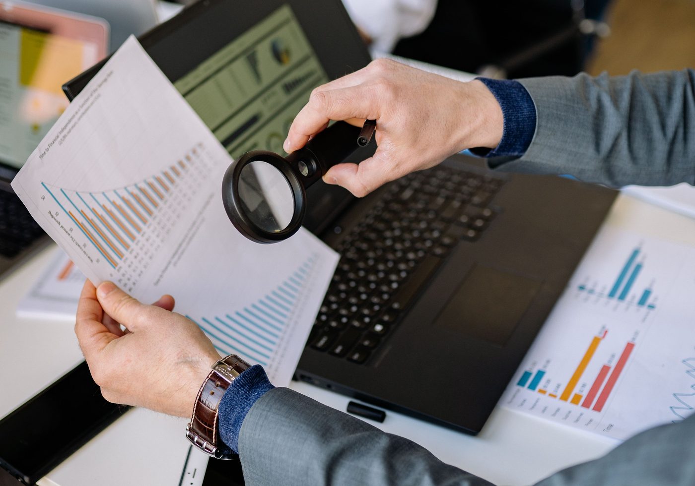 Analyst inspecting a printed data report through a magnifying glass