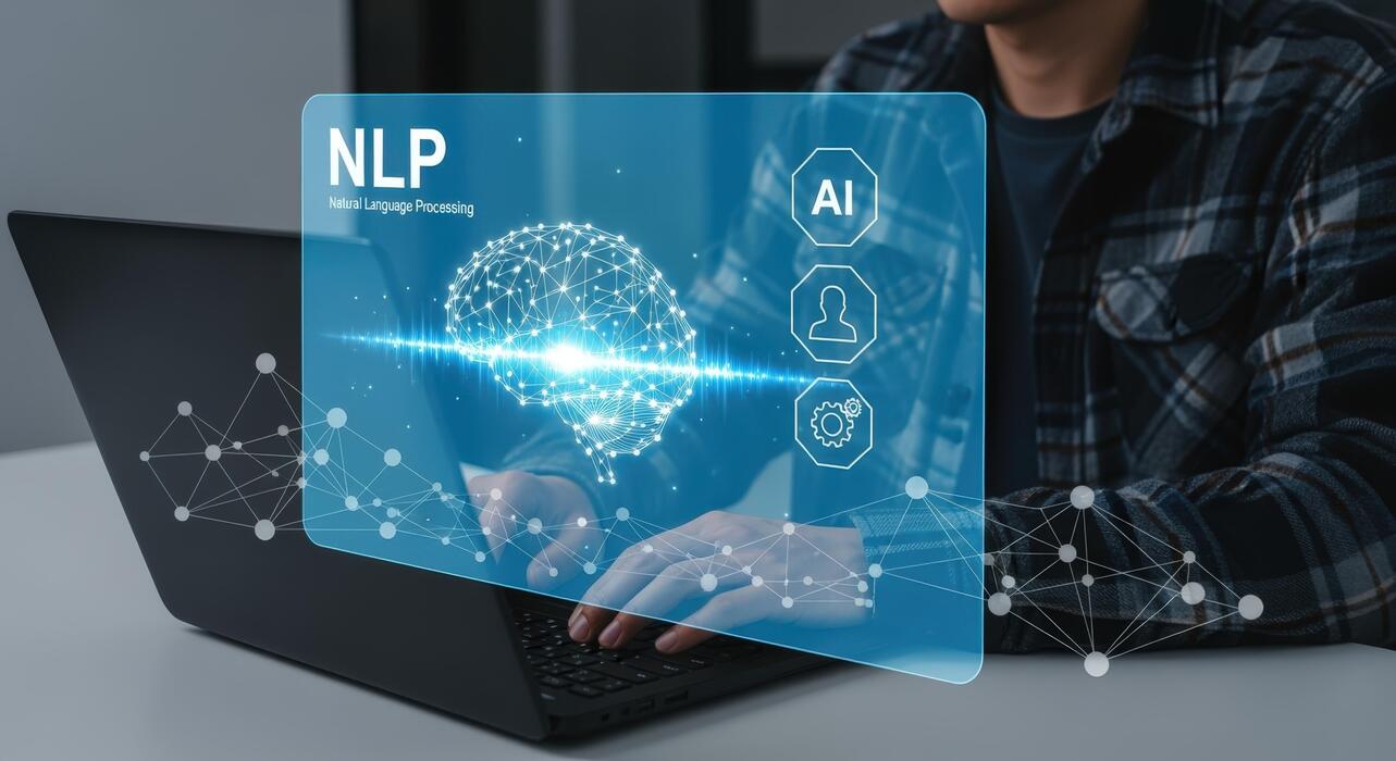 An engineer at a laptop with an NLP panel projected above the keyboard, showing a wireframe brain and a signal waveform