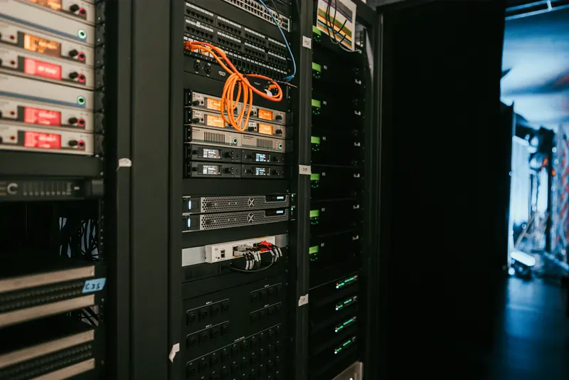 Server racks with orange network cabling in a data centre aisle