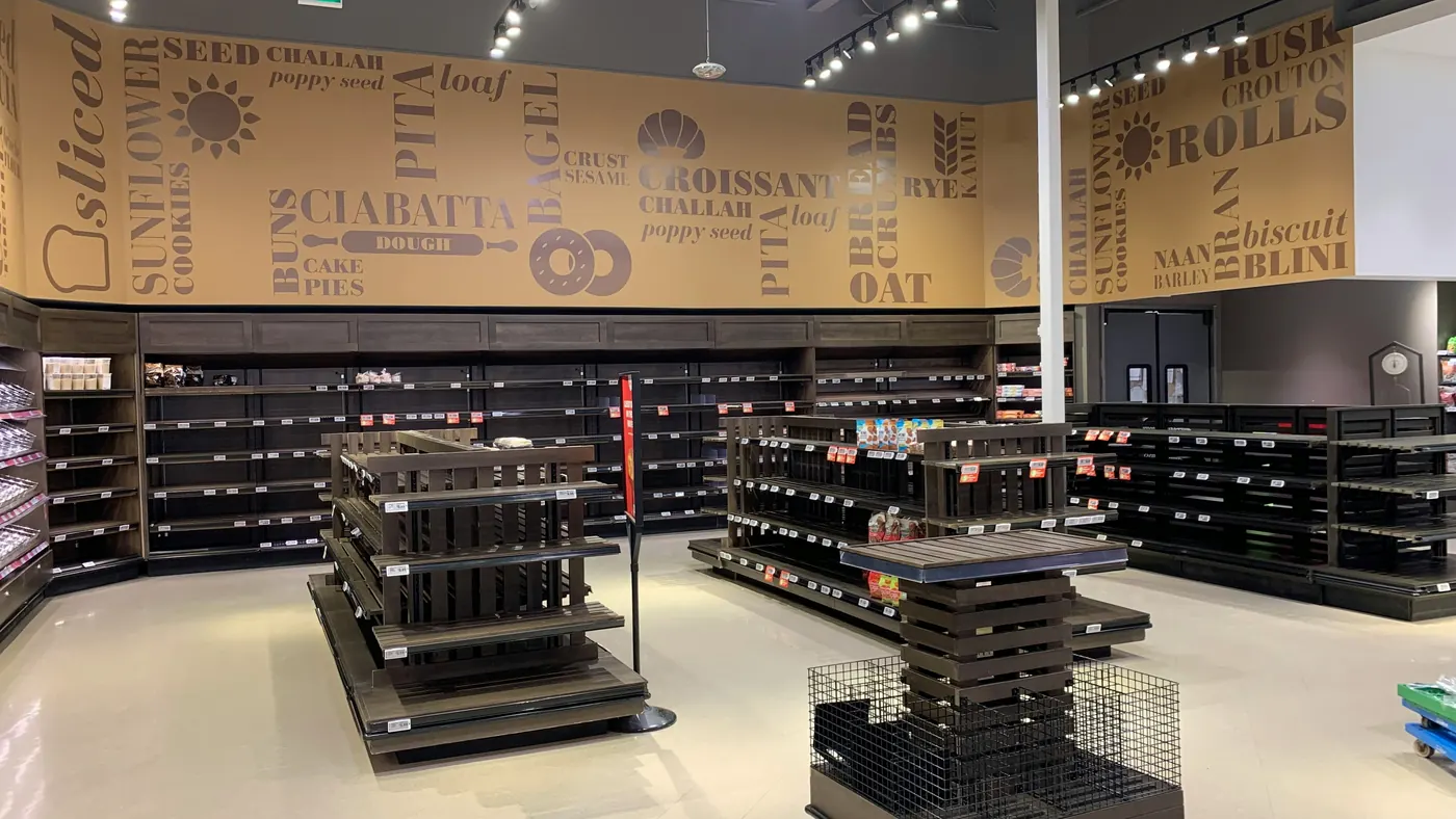 A bakery section of a grocery store with rows of empty shelves