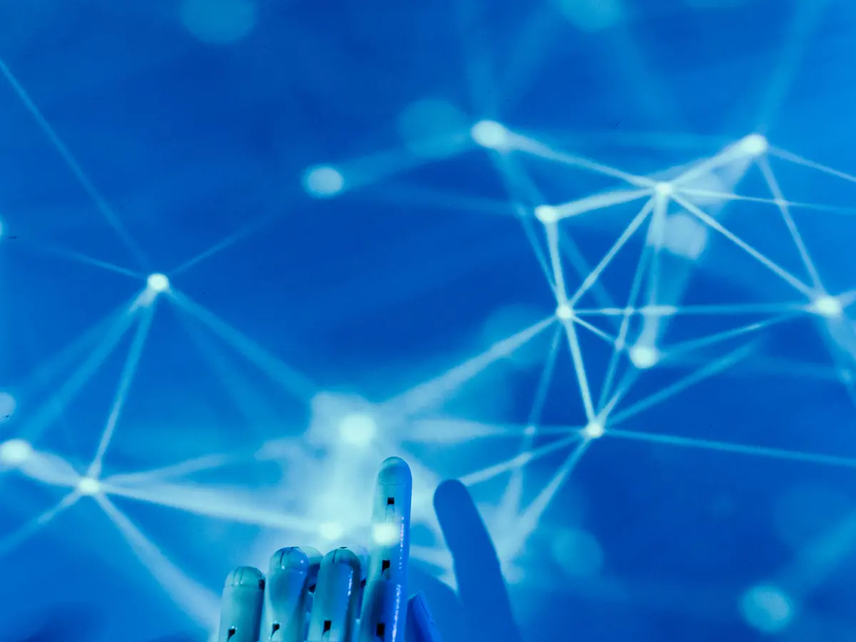 A robotic hand reaching into a connected data network