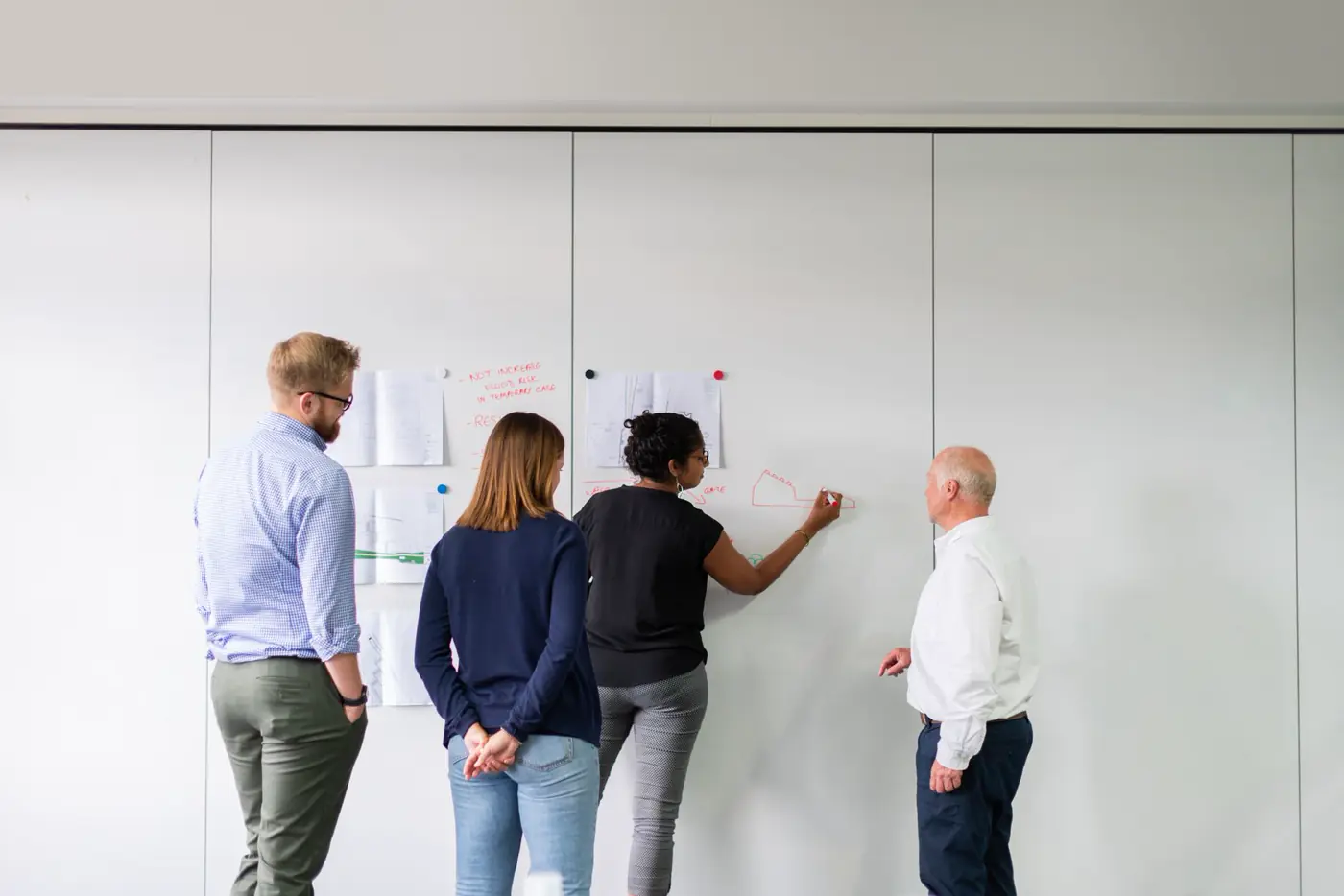 Consultants mapping an insurance process on a whiteboard