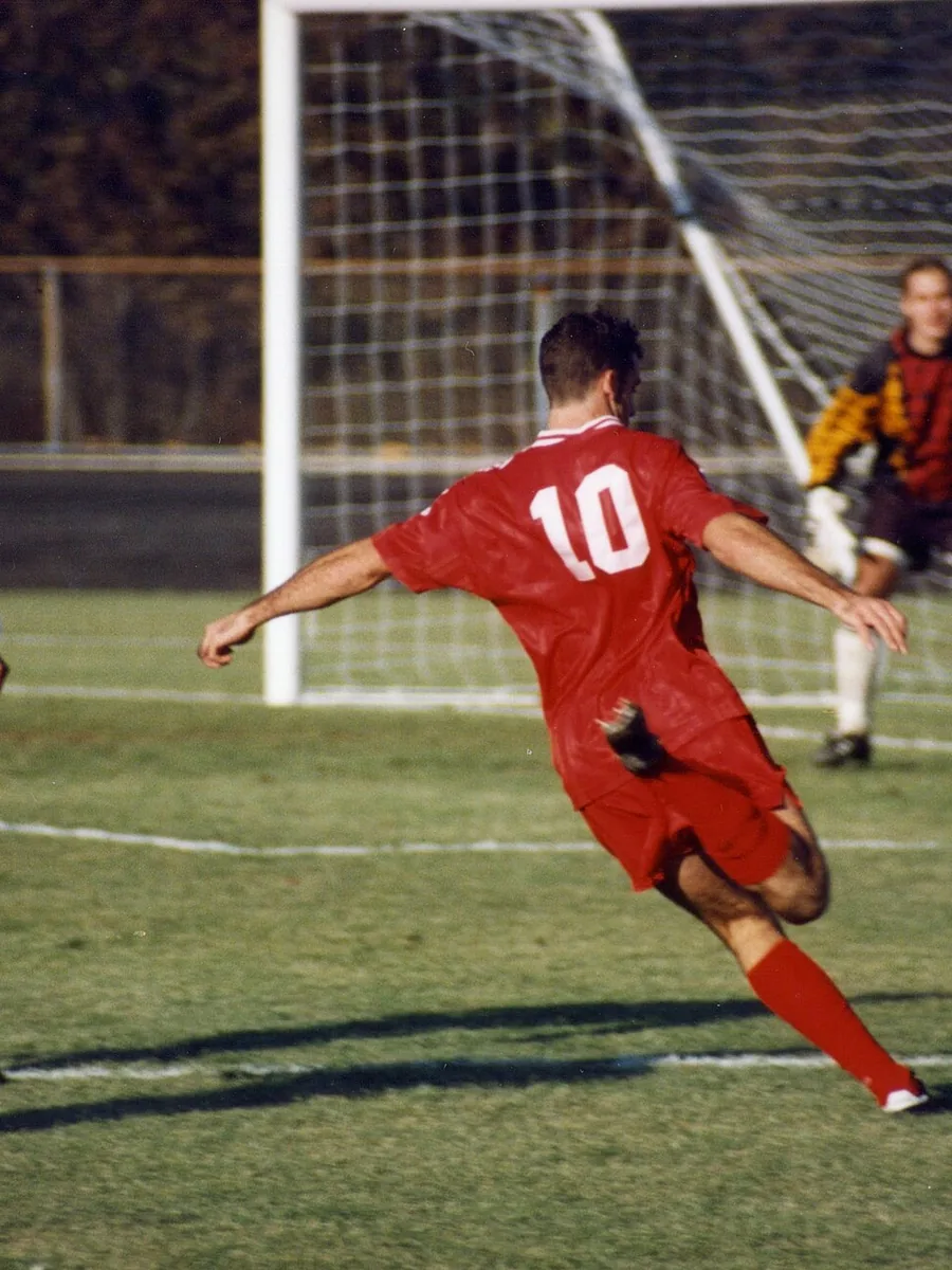 A football resting in the back of a goal net