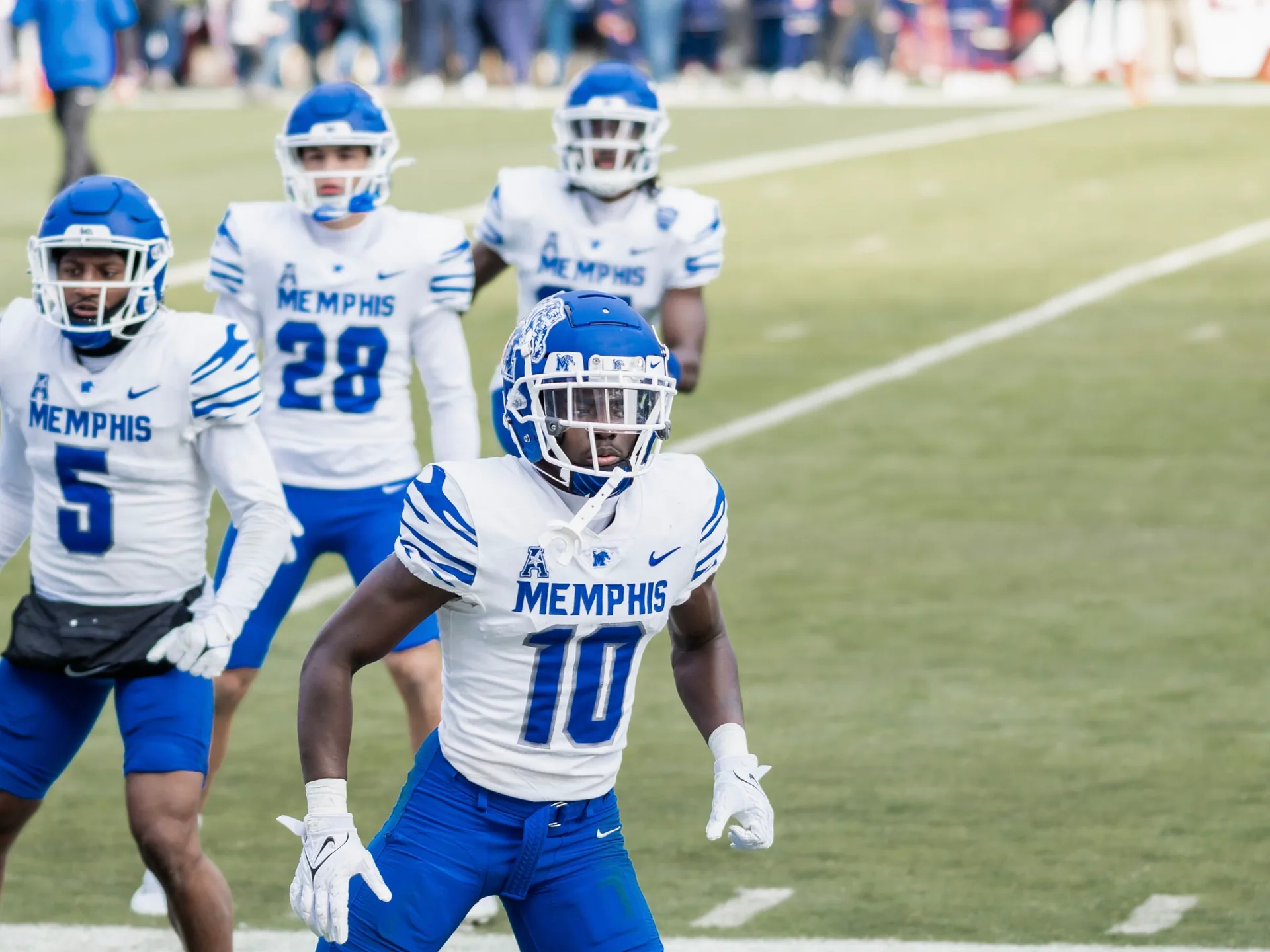 College football players in action on the field during a packed stadium game