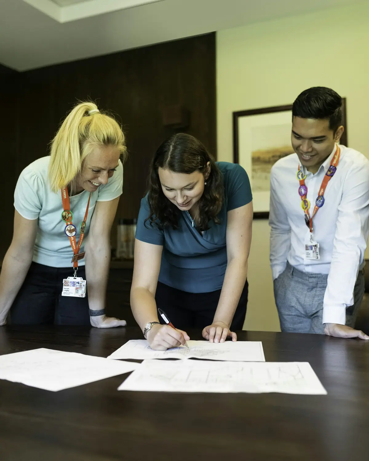 Three school staff members reviewing paperwork together at a desk