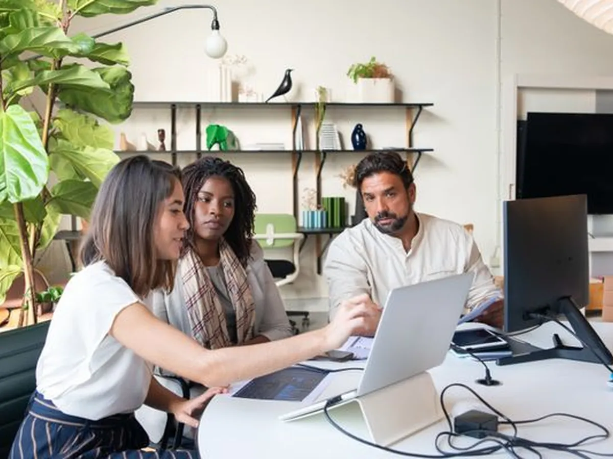 An agency team reviewing campaign work around a laptop
