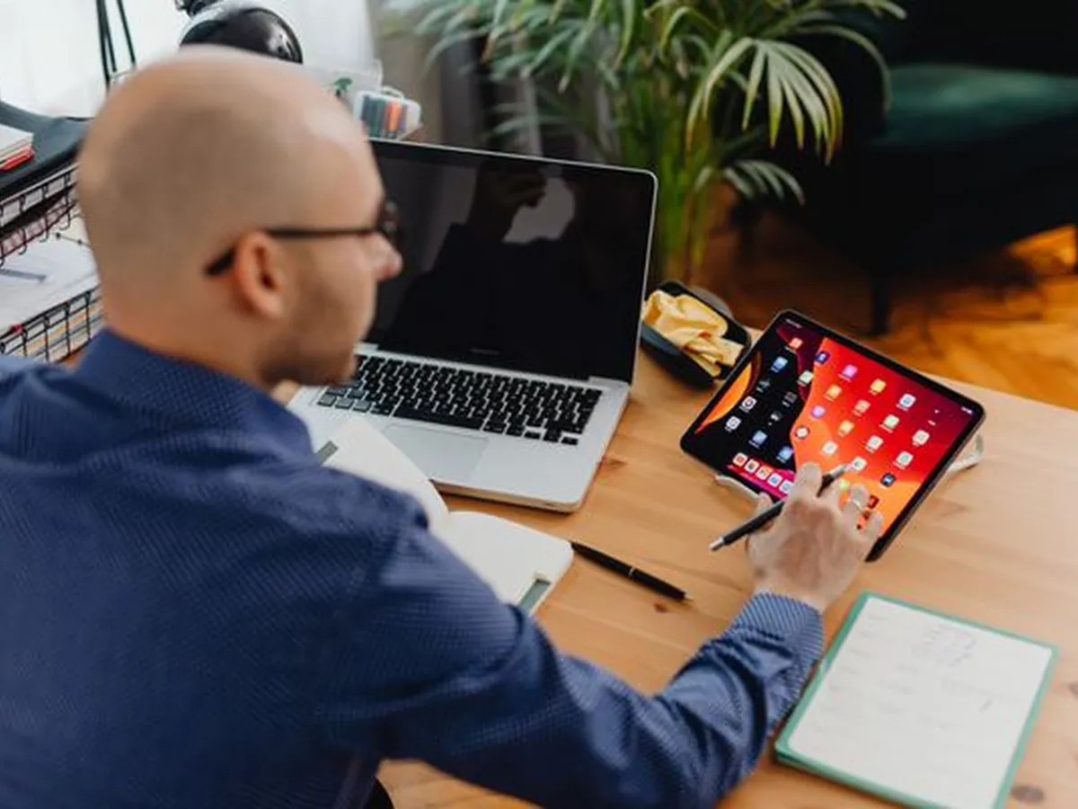 A CRM manager working across a tablet and laptop