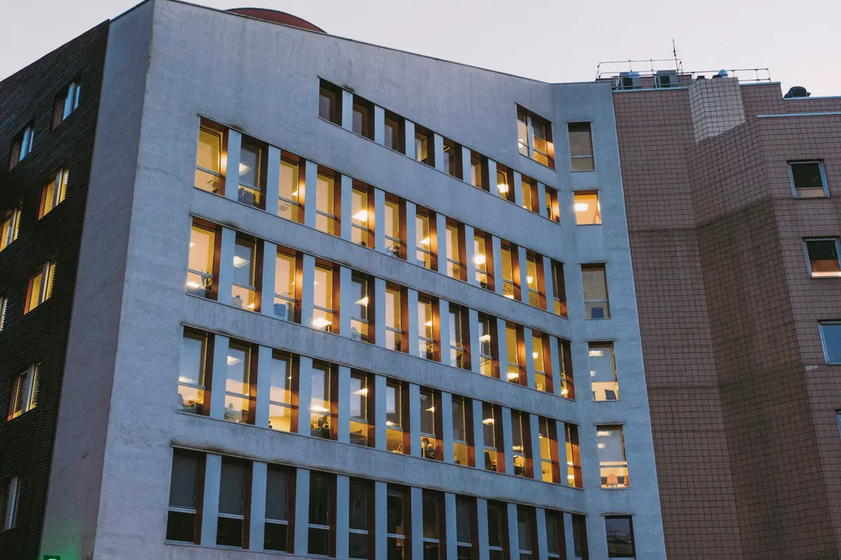 A modern hospital building lit at dusk