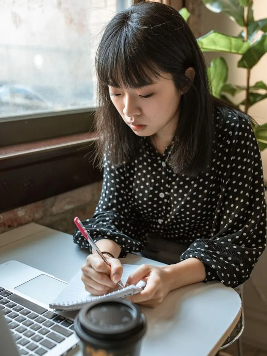 A content strategist drafting an outline in a notebook