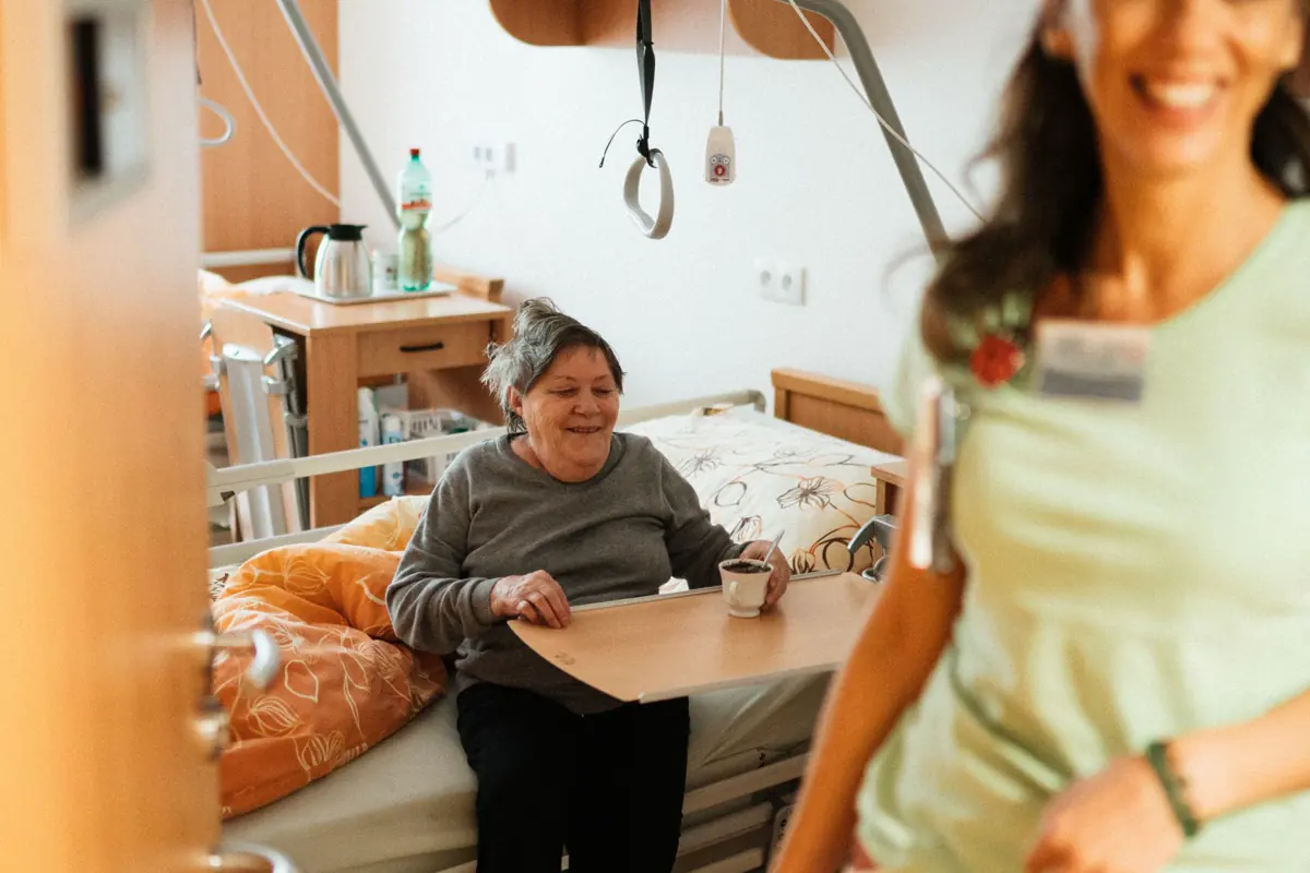 A nurse sitting with an elderly patient