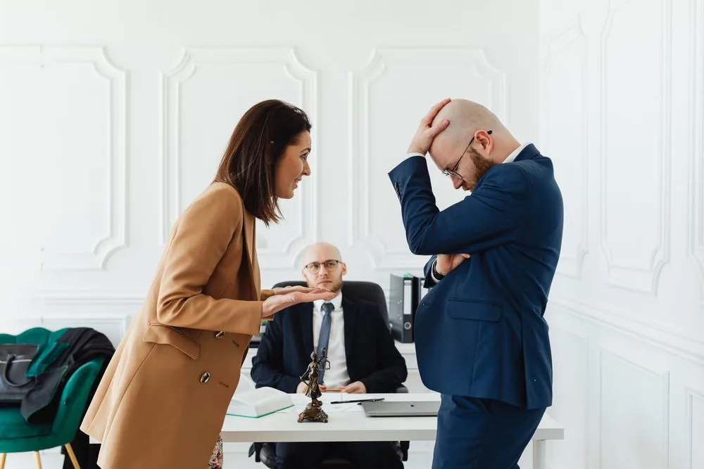 A couple consulting a lawyer across a desk