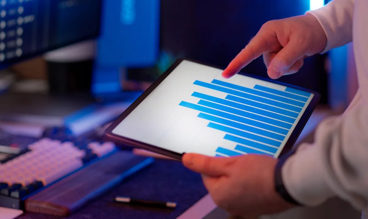 A analyst reviewing performance charts on a tablet