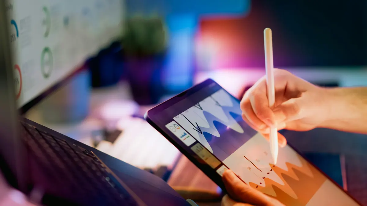 Hand using a stylus to annotate a chart on a tablet