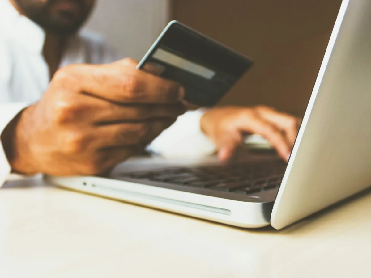 A shopper entering card details on a laptop while shopping online