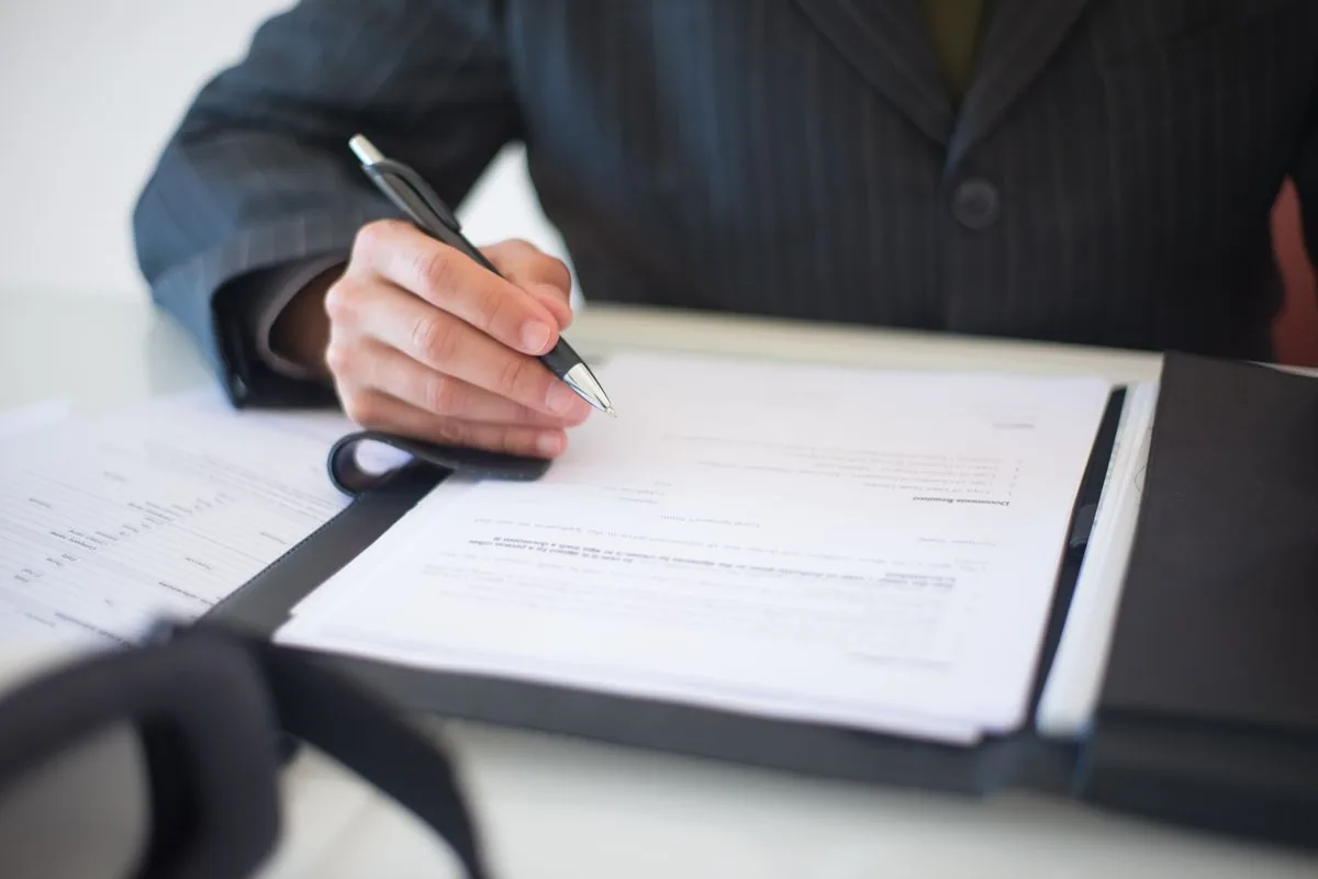 A person signing a contract with a fountain pen
