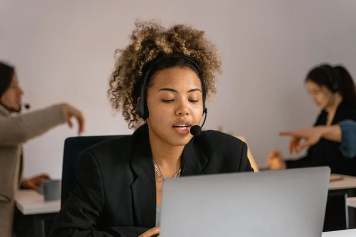 A support specialist working a CRM queue with a headset on