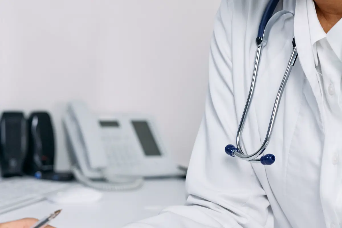 A doctor reviewing patient records at a desk