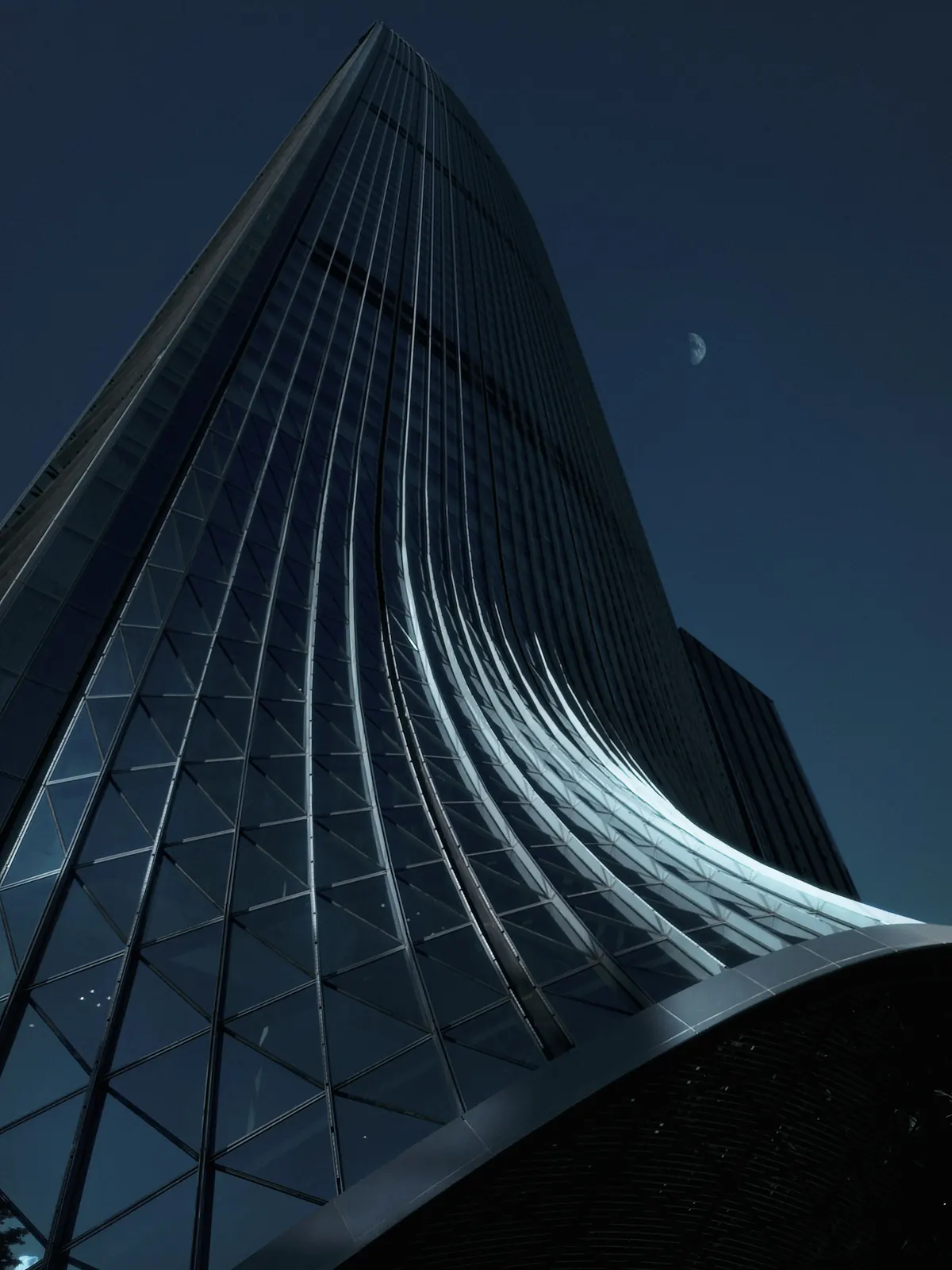 Curved glass facade of a modern office tower at night