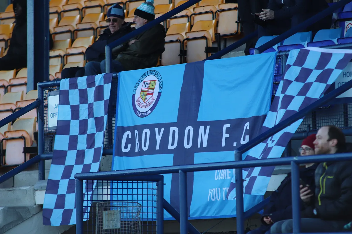 Supporters holding scarves and flags in a stadium stand