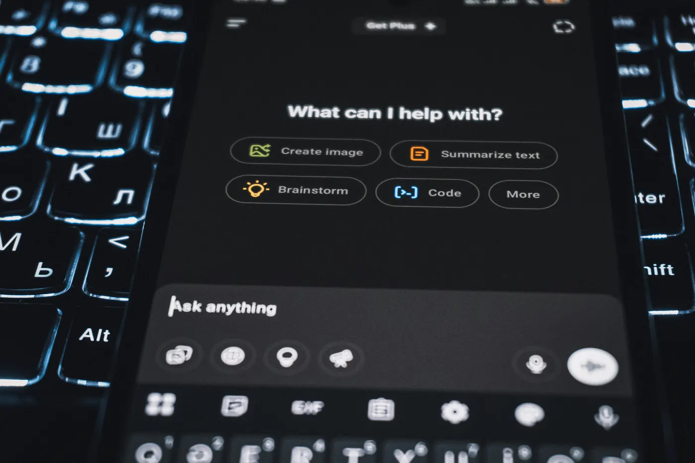 Phone with an AI assistant resting on a backlit multilingual keyboard