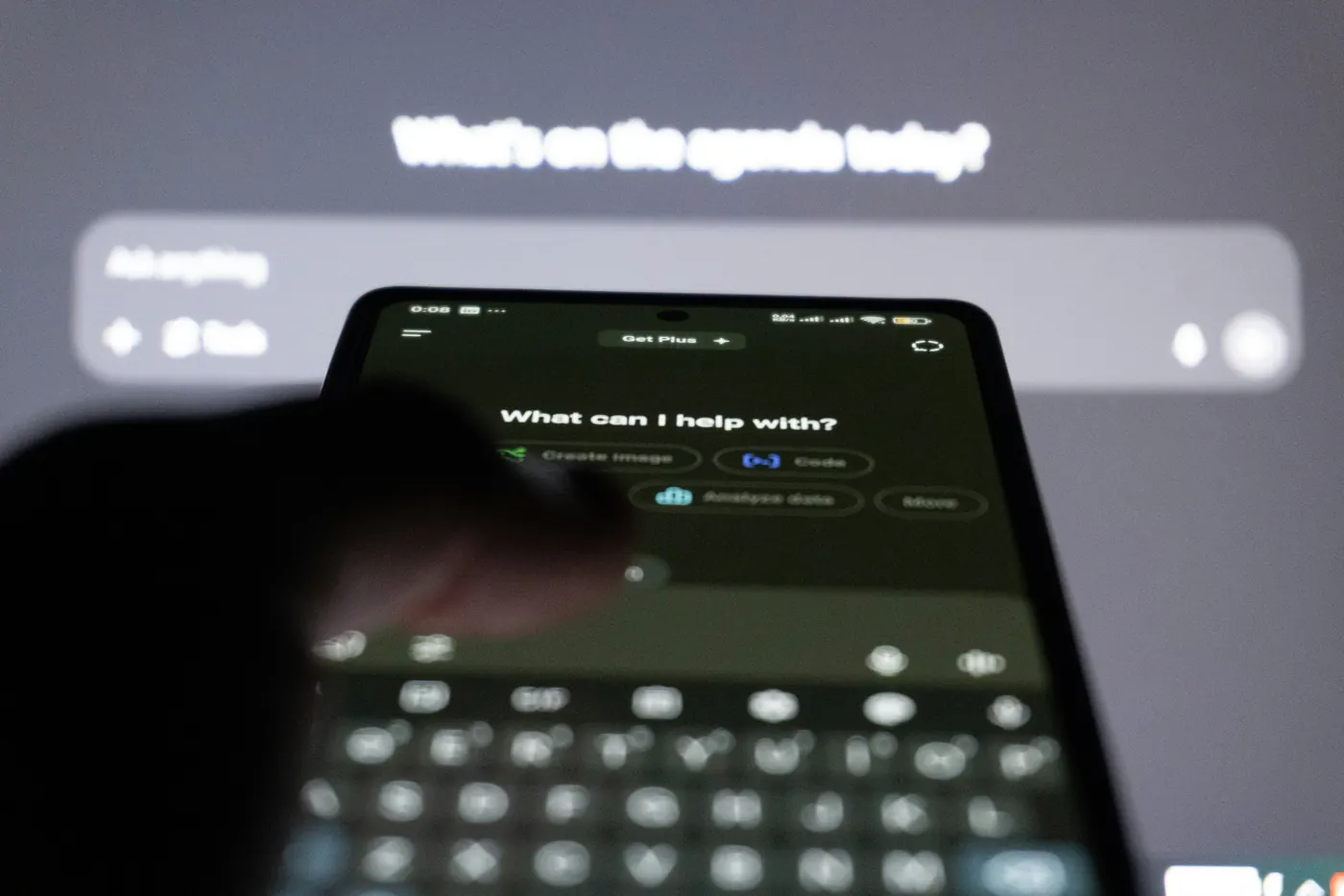 Hand typing a question to an AI assistant on a smartphone