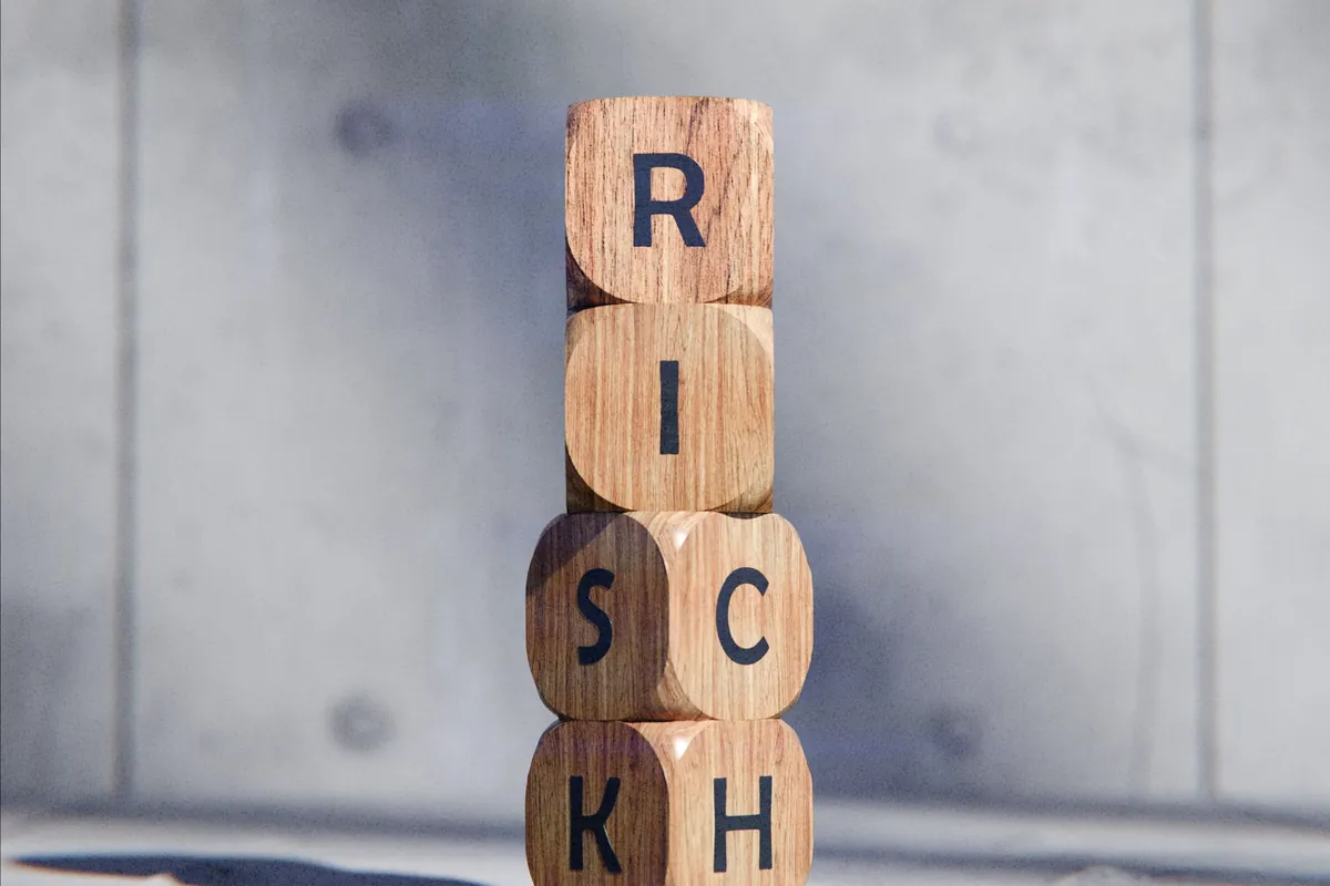 Wooden blocks spelling the word risk stacked on a desk