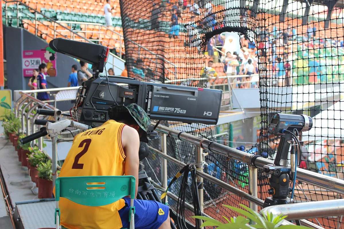 A broadcast camera operator covering a match from the touchline